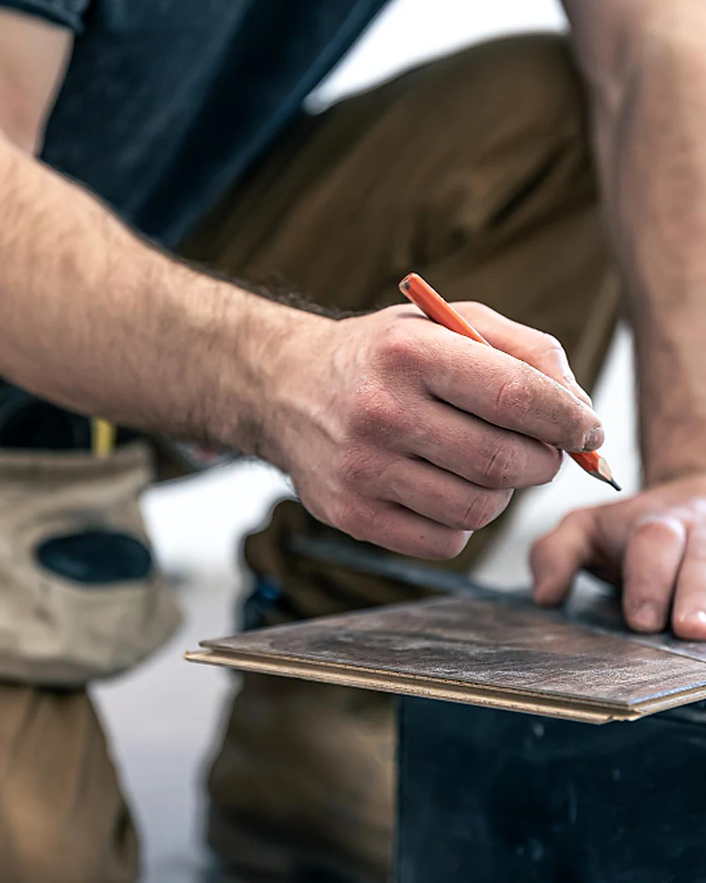 Flooring specialist measuring and marking a plank
